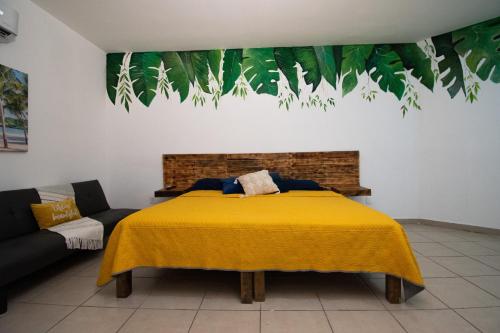 a bedroom with a yellow bed and a couch at Isla Venados Renta Vacacional in Mazatlán