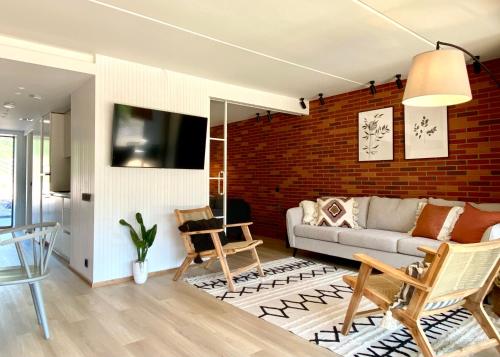 a living room with a couch and a brick wall at SÖRWESPA Nature Resort in Salme