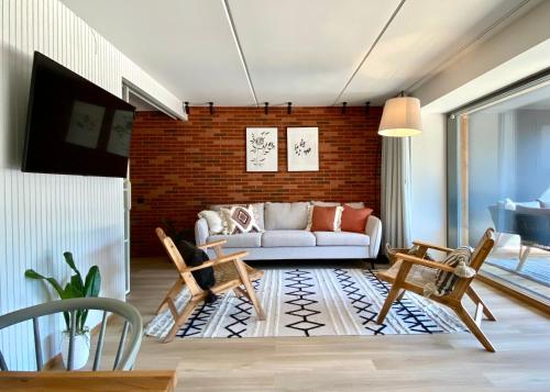 a living room with a couch and a brick wall at SÖRWESPA Nature Resort in Salme