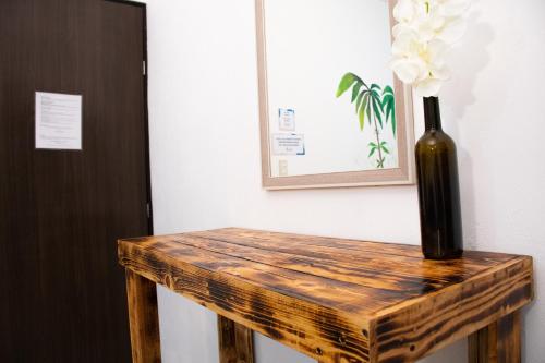 a wooden table with a vase with flowers on it at Isla Venados Renta Vacacional in Mazatlán