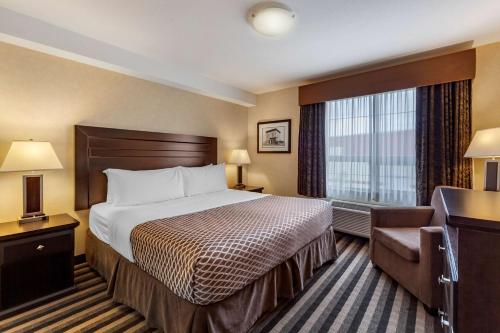 a hotel room with a bed and a chair at Best Western Plus Meridian in Lloydminster