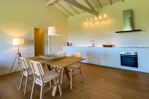 a kitchen and dining room with a wooden table and chairs at The FarmHouse II - Uma quinta deslumbrante in Felgueiras