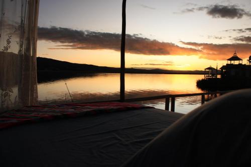 a sunset over a body of water with the ocean at TITICACA JALTAWI LODGE in Puno