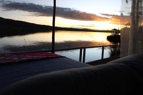 a bedroom with a view of a body of water at TITICACA JALTAWI LODGE in Puno