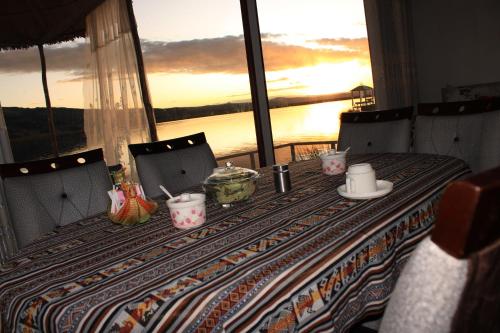 a table in a room with a view of the water at TITICACA JALTAWI LODGE in Puno