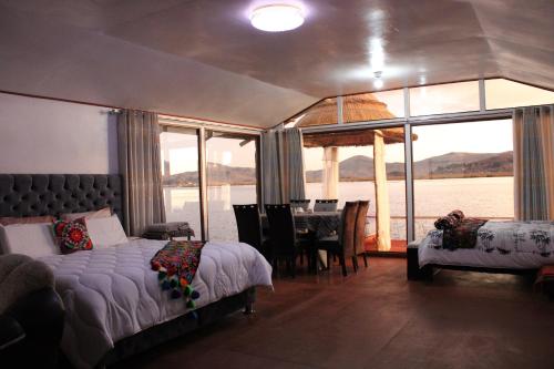 a bedroom with a bed and a dining room with a table at TITICACA JALTAWI LODGE in Puno