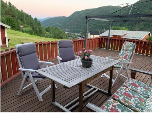 a wooden table and two chairs on a deck at Feriehus med utsikt til fjord og fjell 