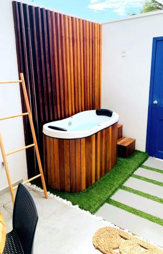 Meditarranee Residence في كاموسين: حوض استحمام في غرفة بجدار خشبي