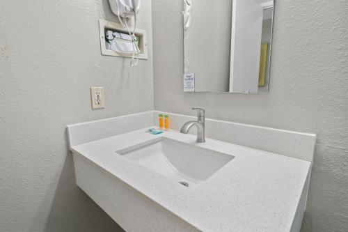 a bathroom with a white sink and a mirror at Travelers Inn Medford I-5 in Medford