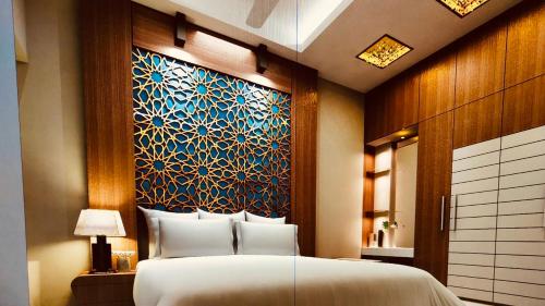 a bedroom with a large bed and a painting on the wall at Hotel Nishi in Balasore