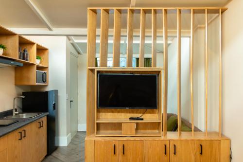 sala de estar con TV en un centro de entretenimiento de madera en CASA NIAGARA, en Ciudad de México