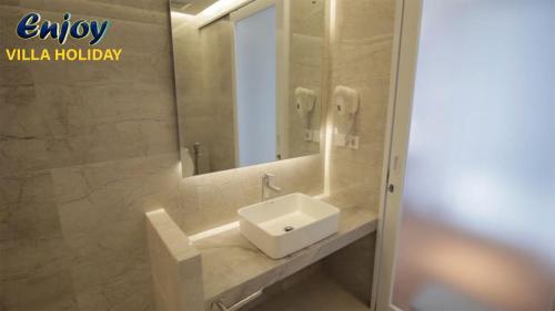 a bathroom with a sink and a mirror at Alulu Luxury Residence - Four Bedroom Villa in Cikundul