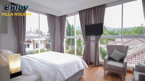 Alulu Luxury Residence - Four Bedroom Villa في Cikundul: غرفة نوم بسرير وكرسي ونافذة كبيرة