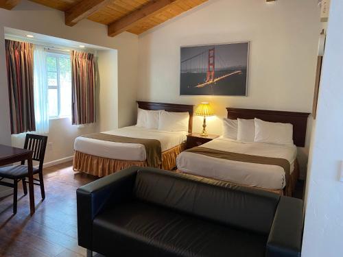 a hotel room with two beds and a couch at Bide-A-Wee Inn and Cottages in Pacific Grove