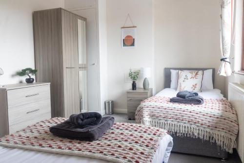 a bedroom with two beds with towels on them at Adrian House, near Hospital, easy parking + garden in Carlisle