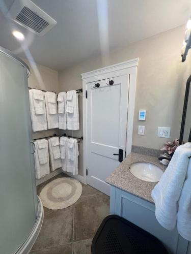 a bathroom with a sink and a shower with towels at The Reminisce vacation home 5br/3bt,downtown BH in Bar Harbor