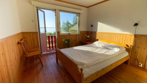a bedroom with a bed and a chair and a window at Lofoten Red Villa in Laupstad