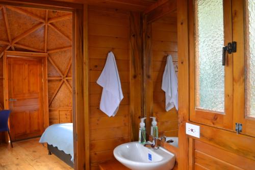 瓜塔維塔的住宿－Arrecife Glamping，一间带水槽的浴室和一张位于客房内的床