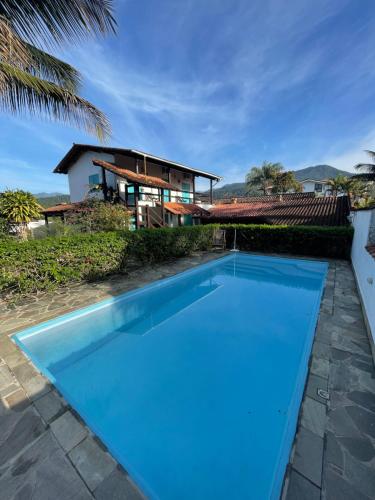 a large blue swimming pool in front of a house at Villa Tiê Paraty in Paraty