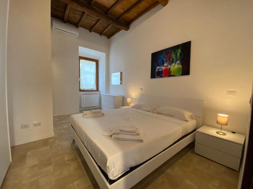 a bedroom with a large white bed in a room at Sasso Grosso House in Ronciglione