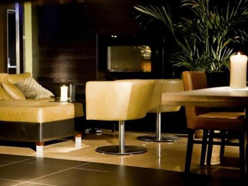 a living room with a table and chairs and a couch at Artto Hotel in Glasgow