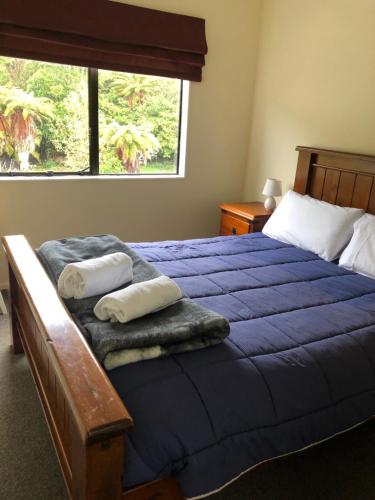 a bedroom with a blue bed with towels on it at Tekoa Lodge Raurimu in Raurimu Spiral