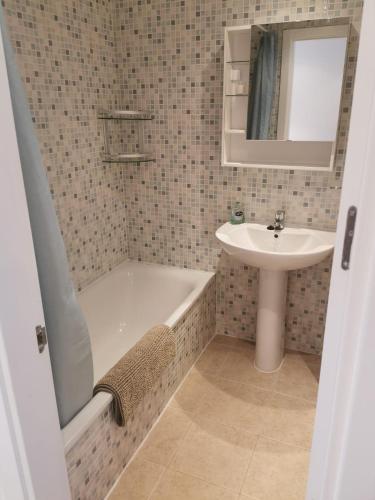 a bathroom with a bath tub and a sink at 2 bedroom Penthouse with a private 360 rooftop terrace with sea and mountain views in Bahia de Casares