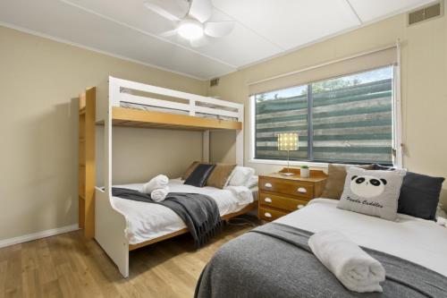 a bedroom with two bunk beds and a window at Metung Akora 2Bdrm Apartment 4 Pets and Boats welcome in Metung