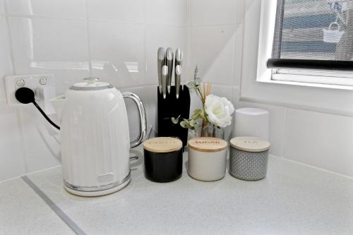 a kitchen counter with a blender and four stools at Metung Akora 2Bdrm Apartment 4 Pets and Boats welcome in Metung