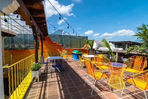 a balcony with tables and chairs on a roof at Why Not Hotel in Antigua Guatemala