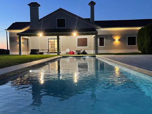 a swimming pool in front of a house at Azores Green Nature in Rabo de Peixe