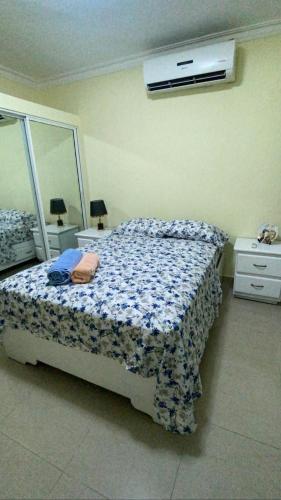 - une chambre avec un lit et un miroir dans l'établissement L&Y Punta Cana Beach Apartament, à Punta Cana