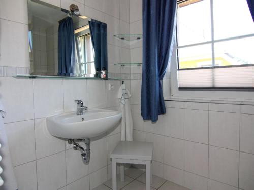 a white bathroom with a sink and a mirror at Semi-detached house, Zingst in Zingst