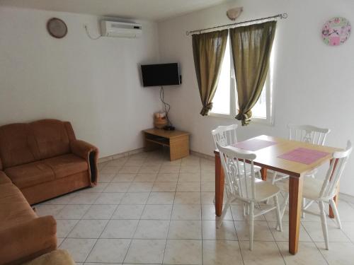 a living room with a table and a couch at Apartments and rooms with parking space Zavala, Hvar - 128 in Jelsa