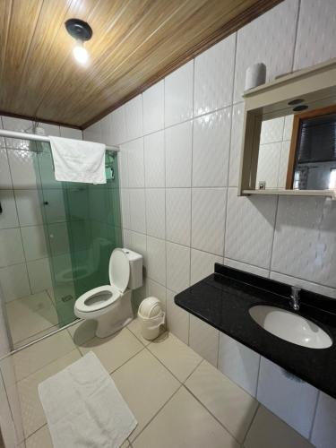 a bathroom with a toilet and a shower and a sink at Pousada Pé Na Areia - ilha do mel in Paranaguá