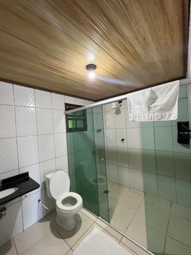 uma casa de banho com um WC e uma cabina de duche em vidro. em Pousada Pé Na Areia - ilha do mel em Paranaguá