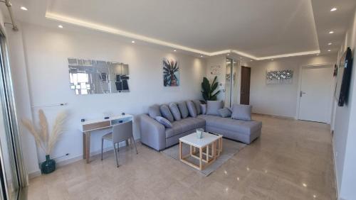 ein Wohnzimmer mit einem Sofa und einem Tisch in der Unterkunft LUXURY APPARTEMENT Vue MER PANORAMIQUE in Antibes