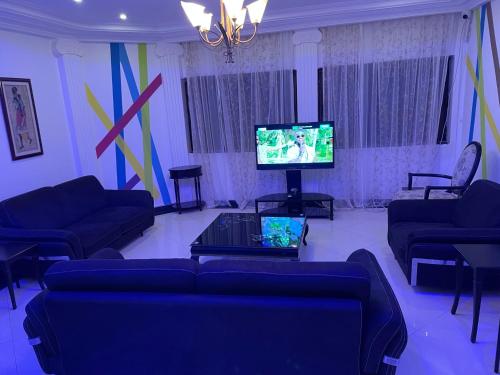 a living room with a couch and a television at HOTEL LES ARCADES in Abomey-Calavi