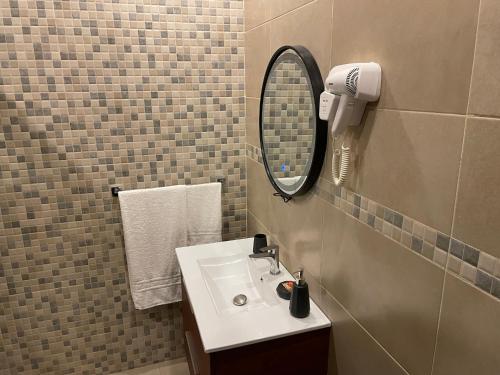 a bathroom with a sink and a mirror at HOTEL LES ARCADES in Abomey-Calavi