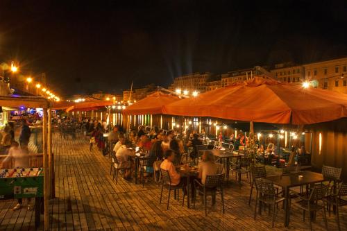 un grupo de personas sentadas en las mesas de noche en Nice apartment on the riverside, en Pisa