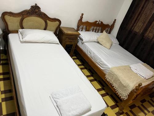 two twin beds in a room with a table at Casa Grande in Medellín