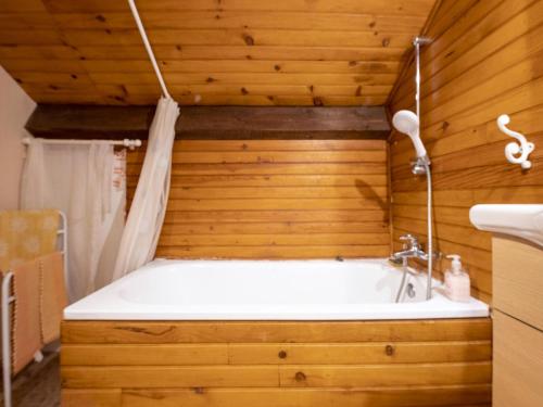 a bathroom with a bath tub in a wooden wall at Inviting holiday home in Miremont with garden in Miremont