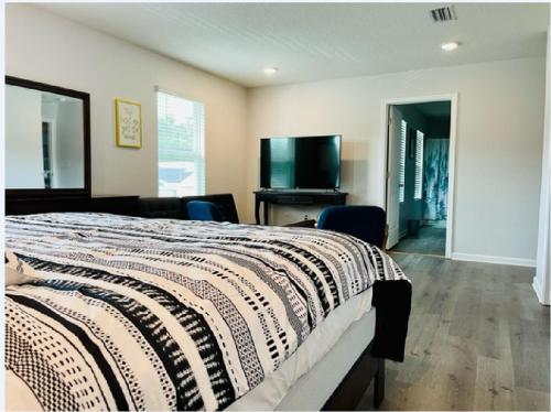 1 dormitorio con 1 cama y TV de pantalla plana en Leny's Place en Pensacola