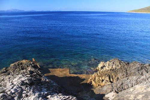 a person standing on the edge of a large body of water at Apartments by the sea Zavalatica, Korcula - 9137 in Zavalatica