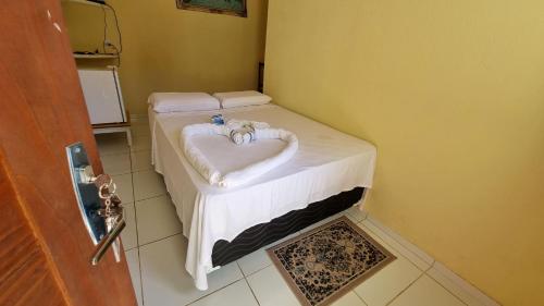 Habitación con cama con toalla en forma de corazón en Pousada Nossa Senhora Das Dores en Maragogi