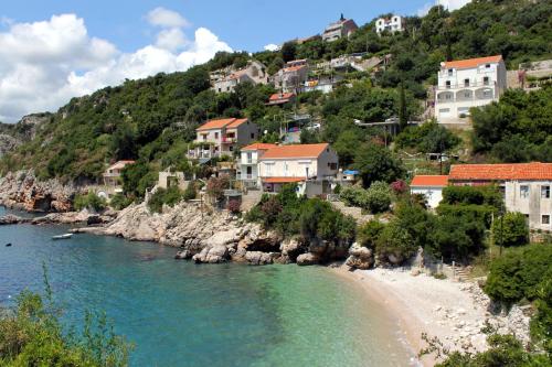 a village on a hill with a beach and houses at Apartments with a parking space Vrbica, Dubrovnik - 9008 in Dubrovnik