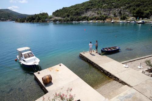 two people standing on a dock with a boat in the water at Triple Room Zaton Mali 8997d in Zaton