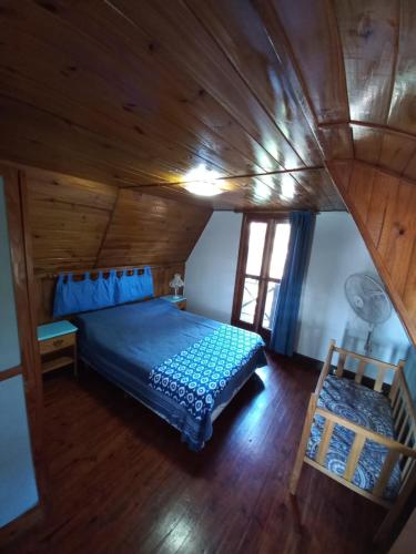 a bedroom with a blue bed and a wooden ceiling at casa 3 amb a 2 cuadras del mar in Mar Azul