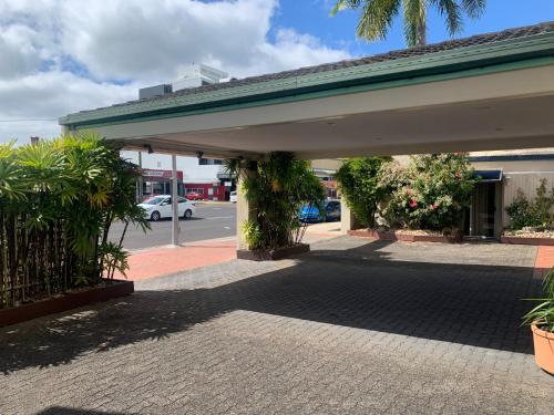 a building with awning and plants on a street at Cairns City Sheridan Motel in Cairns