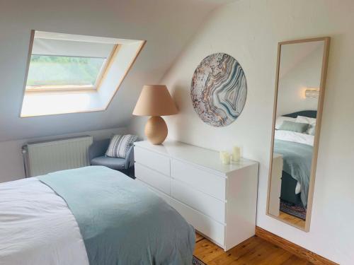 sypialnia z łóżkiem, komodą i lustrem w obiekcie Lovely Meadow House in the land of Croix Scaille w mieście Gedinne